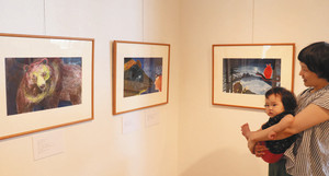 クマを描いた力強い絵（左）などの原画が並ぶ会場＝射水市鳥取で