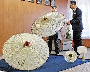 山野之義市長（右）に麻紙で作った和傘を紹介する松田重樹さん＝金沢市役所で