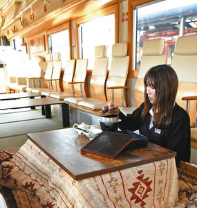畳を敷き、こたつを置いた川風号をＰＲする職員＝関市の長良川鉄道関駅で