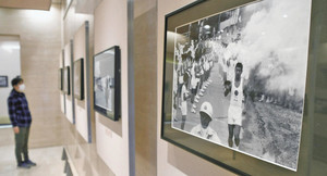応援を受けて走る聖火ランナーたちの写真を展示している会場＝福井市の県立歴史博物館で