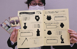 「やや甘口」のシルエットクイズと挑戦するともらえるカードを手にする滝学芸員＝一宮市大和町の市博物館で