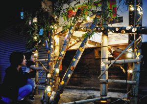 竹筒のイルミネーションの明かりを楽しむ親子＝大桑村の道の駅「木楽舎」で