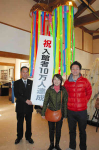 川上館長（左）と１０万人達成を喜ぶ浅井さん（右）と戎さん＝下呂市湯之島の下呂発温泉博物館で