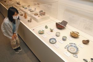 兼六小での発掘調査で見つかった江戸時代の皿やわんなどが並ぶ会場＝金沢市上安原南の金沢縄文ワールドで