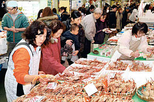 カニなど新鮮な魚介類を求める買い物客＝金沢市無量寺町で