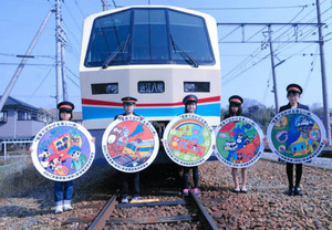 表彰された小学生と電車ヘッドマークデザイン＝東近江市の近江鉄道八日市駅で