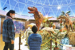 クラフト紙などで作られた大型恐竜模型が展示されている冬の企画展＝坂井市春江町のエンゼルランドふくいで