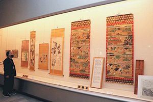 親鸞聖人御絵伝（右の２幅）などが並ぶ会場＝いずれも明和町の斎宮歴史博物館で