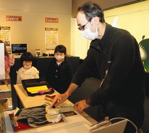 静電気を使った足跡鑑定に興味津々の子どもたち＝富山市西中野町の市科学博物館で