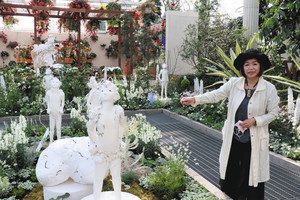 「子どもたちへのエール」を表現した人形彫刻を紹介する瀬川明子さん＝浜松市西区のはままつフラワーパークで