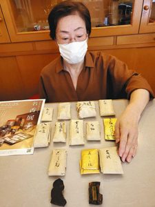 竹紙に包んだ貴重な香木を点検する高沢恵子さん＝金沢市高岡町の香舗伽羅で