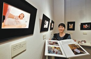 低出生体重児の写真を展示する中嶋麻美さん＝津幡町庄で