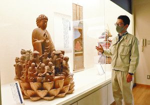 町内の寺が所蔵する「祈り」をテーマにした彫刻作品を紹介する亀田さん＝垂井町タルイピアセンターで