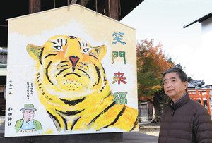トラの大絵馬と、描いた寺田さん＝大津市木下町の和田神社で