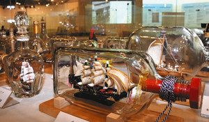 ガラス瓶に精巧な模型が入ったボトルシップの展示＝名古屋市港区港町の名古屋海洋博物館で
