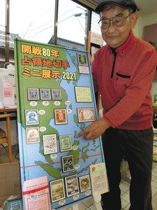 「占領地切手」として展示している岡本孝二さん＝羽咋市の柴垣郵便局で