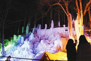 ライトアップされた氷柱を撮影する見物客＝高山市奥飛騨温泉郷一重ケ根で