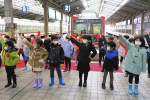 運行開始を前に遊戯を披露する園児たち＝いずれも電鉄富山駅で
