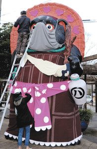 バレンタインにちなんだ新しいデザインの衣装に着せ替えられた大たぬき像＝甲賀市信楽町で