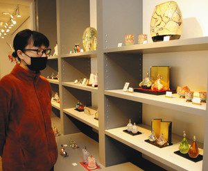 棚に並ぶ色鮮やかなガラス製のひな人形＝富山市古沢の富山ガラス工房で