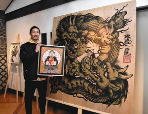 竜を描いた１．８メートル四方の作品の前で宮崎さんと合作した作品を手にする木全さん＝いずれも多治見市本町のなでしこ蔵で