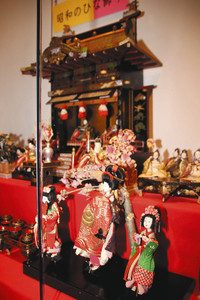 昭和初期に東海地方で作られたひな飾り。手前は花魁道中の人形。奥の御殿飾りの屋根にはしゃちほこが付いている＝いずれも金沢市飛梅町の金沢くらしの博物館で