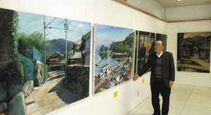 展示会場で作品を解説する野村さん＝鳥羽市の商業施設ハローで