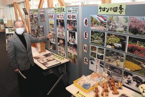 「ケロンの小さな村」の記録が並ぶ展示を紹介する上乗秀雄さん＝能登町柳田仁で