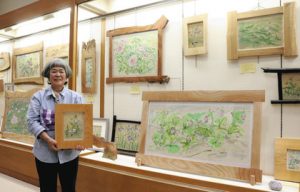 自分で育てた草花の水彩画を紹介する阿波連さん＝東近江市の八日市図書館で