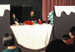 人形劇「てぶくろ」を披露するメンバー＝能美市辰口図書館で
