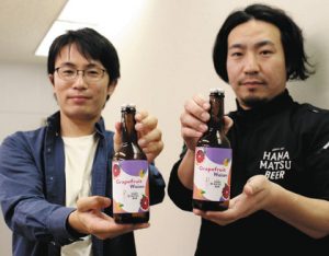 浜松産グレープフルーツを使ったクラフトビールを持つ杉本大樹さん（右）と石川大輔さん＝浜松市役所で