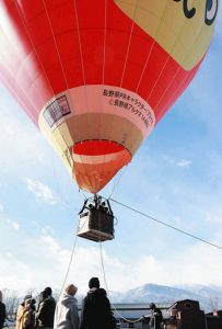 浮き上がる気球を見送る人々＝安曇野市穂高の大王わさび農場で