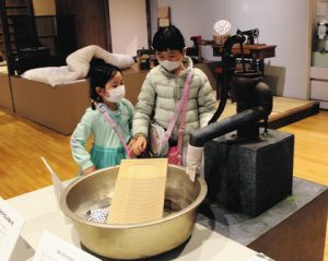 井戸の模型や洗濯板の展示は触ることもできる＝いずれも四日市市安島の市立博物館で