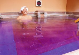 赤ワインを連想させる鮮やかな紫色に染まった露天風呂＝金沢市神宮寺の「湯けむり屋敷　和おんの湯」で