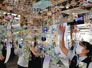 コンコースに３００個の風鈴を飾る駅員ら＝諏訪市のＪＲ上諏訪駅で