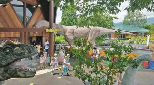 今回新たに設置され、訪れた園児を出迎える実物大のカマラサウルス（中央）。奥右の建物は新設のヴェロキ館＝勝山市の長尾山総合公園で