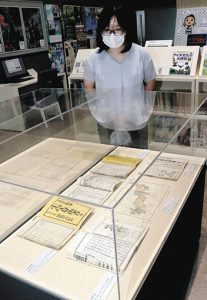 展示された昔の教科書を説明する世古さん＝松阪市小野江町の松浦武四郎記念館で
