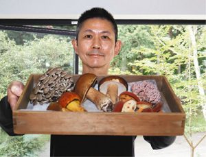 料理に使う採れたてのキノコを紹介する青木さん＝高山市荘川町で