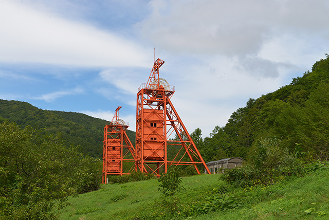 三菱美唄炭鉱跡に現存する竪抗巻揚櫓（奥に見えるのは開閉所）供に近代産業遺産に指定されている。170mの地底まで鉱員を運び原炭を地上に運んだ。