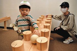 木のおもちゃで遊ぶ子ども（左）＝岡崎市岡町のおかざき世界子ども美術博物館で
