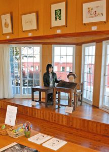 トットちゃんの座る「フタつきの木製机」（中央右）と一緒に記念撮影できるトモエの講堂