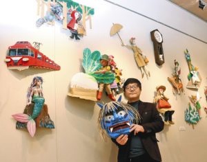 童話を題材にした作品や鬼の面を出品した暮石さん＝いずれも関市小屋名の県博物館で