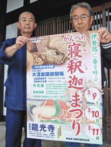 「かんべの寝釈迦まつり」開催を知らせるポスターを手にする衣斐玄譲住職（左）ら＝鈴鹿市神戸の龍光寺で