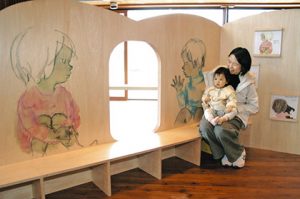 絵本を立体形にしたような「絵本を見るための遊具」で、ちひろの絵を楽しむ親子＝いずれも松川村の安曇野ちひろ美術館で