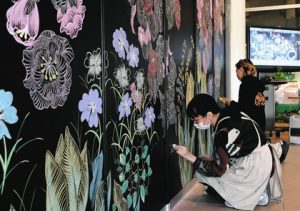 チョークで丁寧に花を描く高津さん（手前）と古関さん＝長久手市の愛・地球博記念公園で