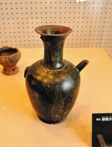 平出遺跡の大規模発掘調査のきっかけをつくった県宝「緑釉水瓶」。取っ手部分が欠けている＝いずれも塩尻市宗賀の市立平出博物館で