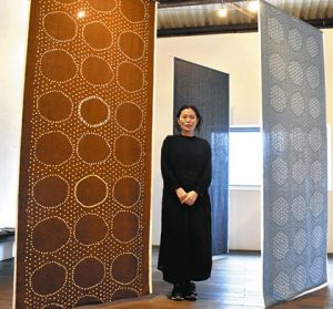 展示する大きなテキスタイル作品と伊藤さん＝伊賀市丸柱で