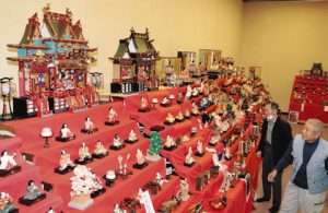 御殿などきらびやかなひな飾りを並べた串町民俗資料館のメンバー＝小松市立博物館で