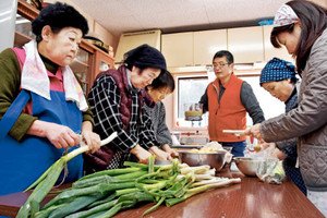 地元産の野菜を使ったキムチ作りに取り組む住民ら＝氷見市仏生寺の脇之谷内公民館で