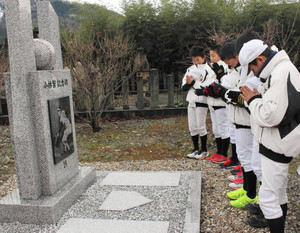 完成した小林繁さんの記念碑に手を合わせるオールスター福井の選手たち＝永平寺町東古市の本覚寺で